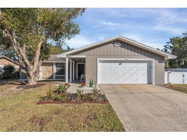 Cute ranch home with a white garage door and landscaped lawn at 1107 Lantana Dr, Eustis, FL 32726