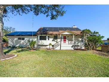 House exterior features a solar panel system and a spacious lawn at 1141 Edgewood Ranch Rd, Orlando, FL 32835