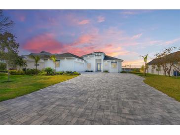 Stunning waterfront home with a paver driveway and beautifully landscaped lawn at 118 River Ln, Ormond Beach, FL 32176