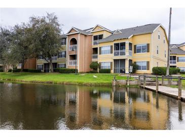 Waterfront condos with colorful facade, private balconies, and dock access on a tranquil pond at 2302 Midtown Ter # 1228, Orlando, FL 32839