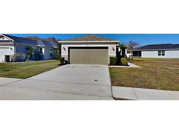 House exterior view showing a two-car garage and well-maintained lawn at 4601 Glencrest Loop, Saint Cloud, FL 34772