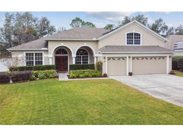 Beautiful two-story home with red front door and 3-car garage at 971 Worthington Ct, Oviedo, FL 32765