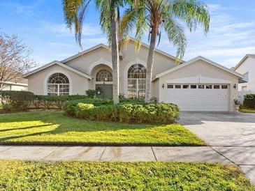 House exterior with a two-car garage and nicely landscaped yard at 11016 Orangeshire Ct, Ocoee, FL 34761