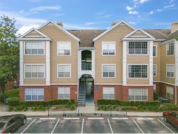 Tan and brick two-story condo building with parking and landscaping at 13103 Mulberry Park Dr # 811, Orlando, FL 32821