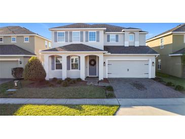 Two-story house with gray siding, gray shutters, and a paved driveway at 165 Williamson Dr, Davenport, FL 33897