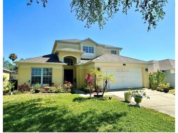 Two-story house with a landscaped yard and attached garage at 1708 Clubhouse Cv, Haines City, FL 33844