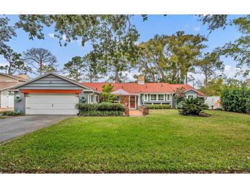 Cute ranch home with a red door and nicely landscaped lawn at 1871 Linden Rd, Winter Park, FL 32792