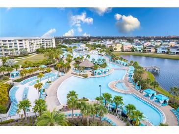 Expansive resort-style pool area with ample seating, lush landscaping and adjacent lake views at 2904 On The Rocks Pt, Kissimmee, FL 34747