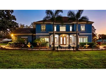 Elegant blue two-story home with a meticulously landscaped front yard and covered entrance at 3943 W Campbell Rd, Lakeland, FL 33810