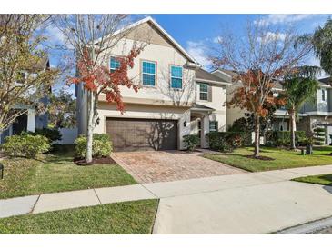 Two-story house with brown brick driveway and landscaping at 611 Marsh Reed Dr, Winter Garden, FL 34787