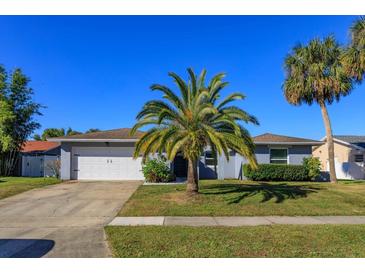 Single-story home with a white garage door and palm trees in the front yard at 1354 Tierra Cir, Winter Park, FL 32792