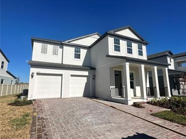 Two-story house with white siding, gray accents, and a two-car garage at 16337 Silver Grove Blvd, Winter Garden, FL 34787