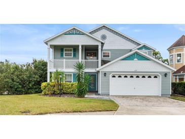 Two-story house with gray siding, teal accents, and a two-car garage at 2119 Victoria Dr, Davenport, FL 33837
