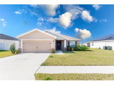 Suburban home with 2-car garage, landscaped lawn and solar panels at 878 Galloway St, Lake Alfred, FL 33850