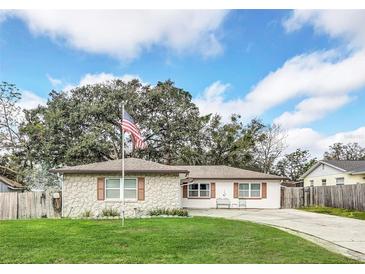 Charming single-story home with a well-manicured lawn and an American flag waving in the front yard at 8836 Ava Lake Dr, Orlando, FL 32810