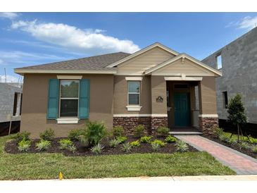 One-story home with teal shutters, landscaping, and a brick walkway at 16704 Point Rock Dr, Winter Garden, FL 34787