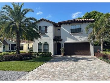 Inviting two-story home with a well-manicured lawn and a tile roof and paver driveway at 205 Hazard St, Orlando, FL 32804