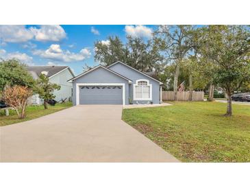 Gray house with a two-car garage and well-maintained lawn at 100 Kelly Cir, Sanford, FL 32773