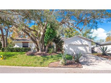 House exterior features a light-colored facade, landscaping, and a driveway at 100 Ledbury Dr, Longwood, FL 32779