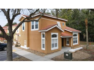 Two-story house with orange exterior, tile roof, and landscaping at 1001 Park Ridge Cir, Kissimmee, FL 34746