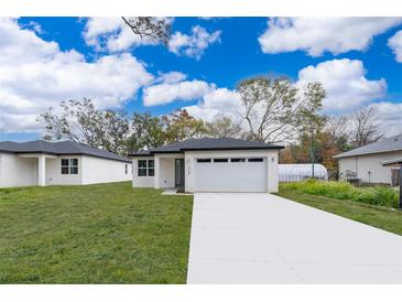 Newly constructed home with a white exterior, gray accents, and a two-car garage at 2909 S Palmetto Ave, Sanford, FL 32773