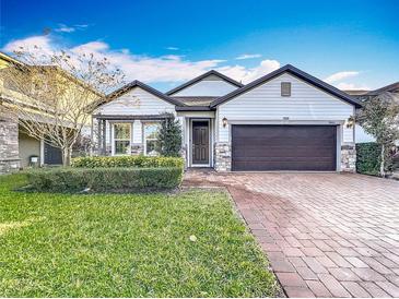 Two-story house with a brick paved walkway, a two-car garage, and well-manicured lawn at 3465 Middlebrook Pl, Harmony, FL 34773