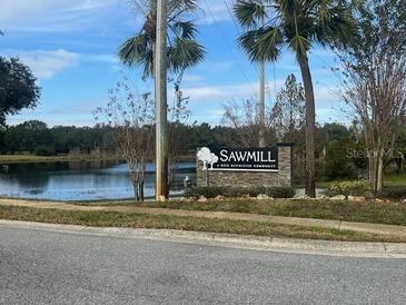 Sawmill community entrance with a pond and lush landscaping at 5022 Log Wagon Rd, Ocoee, FL 34761