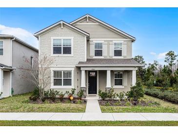 Two-story house with gray siding, a dark door, and a landscaped lawn at 11833 Founders St, Orlando, FL 32832