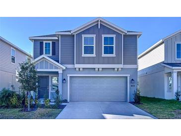 Two-story house with gray siding, attached garage, and landscaping at 1534 Marksman Rd, Eagle Lake, FL 33839