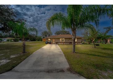 Charming single-story home with palm trees, long driveway, and cozy front porch at 160 Clay Cut Cir, Haines City, FL 33844