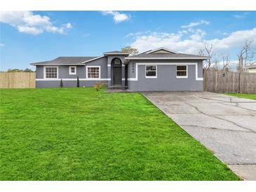 Newly renovated home with gray exterior, spacious lawn, and a driveway at 3662 Mohawk Dr, Mount Dora, FL 32757