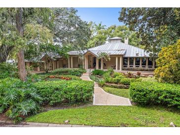 House exterior featuring a metal roof, landscaped grounds, and walkway at 451 Northwind Rd, Maitland, FL 32751