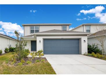 Two-story house with gray siding, two-car garage, and landscaping at 5302 Royal Point Ave, Kissimmee, FL 34746