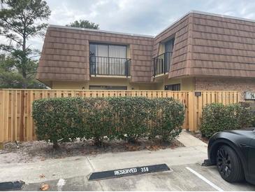 Two-story townhome with wood-style siding and a fenced yard at 5392 Elm Ct # 363, Orlando, FL 32811