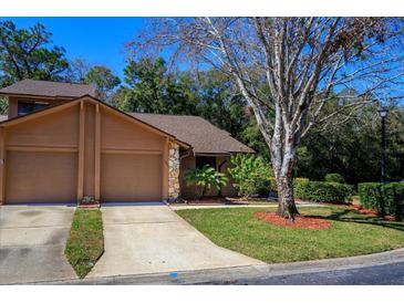 Charming home featuring a two-car garage, well-maintained lawn, and mature landscaping at 596 Albany Pl, Longwood, FL 32779