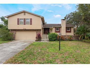 Tan two-story house with a brown door and attached garage at 602 Iris St, Altamonte Springs, FL 32714