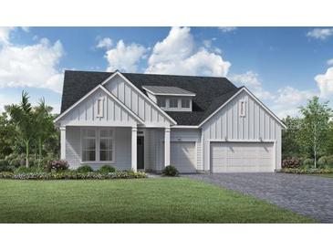 Two-story farmhouse style home with white siding, gray roof, and a two-car garage at 6216 Trailblaze Bnd, St Cloud, FL 34771