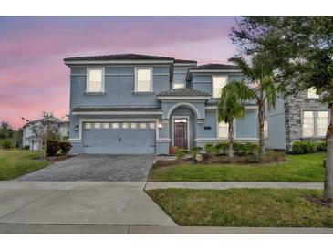 Two-story house with gray siding, gray garage door, and landscaping at 1533 Maidstone Ct, Champions Gate, FL 33896