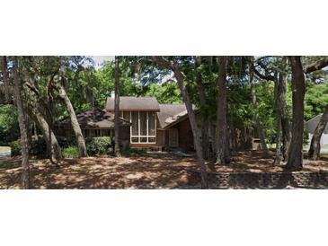 Two-story house with brick facade and large windows, nestled among mature trees at 1542 Sugarwood Cir, Winter Park, FL 32792