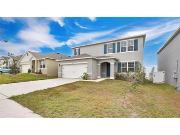 Two-story house with gray siding, white garage door, and landscaped lawn at 1794 Hackberry St, Clermont, FL 34715