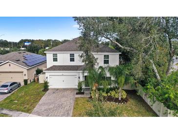 Two-story house with a white exterior, paved driveway, and landscaping at 2041 Brillante Dr, St Cloud, FL 34771