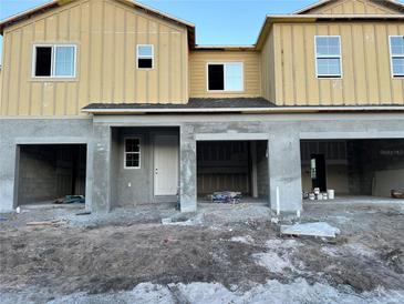 New two-story townhome featuring an attached two-car garage under construction at 4299 Campsite Loop, Orlando, FL 32824