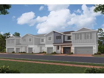 Modern townhome with two-tone exterior and attached garage at 4299 Campsite Loop, Orlando, FL 32824