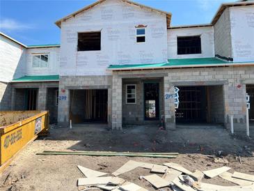 New townhomes under construction, featuring block construction, Tyvek weather barrier, and garage entries at 4303 Campsite Loop, Orlando, FL 32824