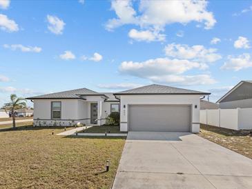 Newly built home with gray garage door and landscaped lawn at 803 Fraser Dr, Poinciana, FL 34759