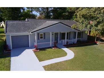 Newly renovated single-story home with gray exterior, landscaping, and a paved driveway at 10118 Allenby Ct, Orlando, FL 32821