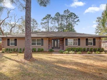 Tan house with stone accents, landscaping, and a spacious lawn at 126 Se 41St Ave, Ocala, FL 34471