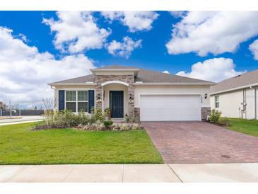 One-story home with brick paver driveway and landscaped front yard at 1550 Outback Rd, St Cloud, FL 34771