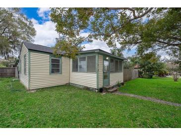 Charming yellow house with green trim, spacious yard, and mature trees at 1601 New York Ave., St Cloud, FL 34769