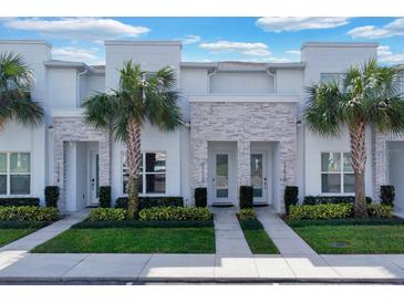 Modern townhouses with light stone accents and lush landscaping at 17526 Hidden Forest Dr, Clermont, FL 34714